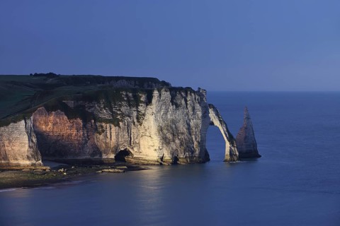 Cliffs with the Falaise d'Aval rock gate and the Aiguille d'Etretat rock needle at night, Etretat,