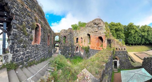 Panoramic photo of interior of northern inner part with partially restored secured masonry of ruins