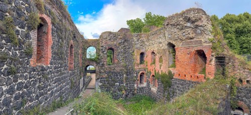Panoramic photo of interior of northern inner part with partially restored secured masonry of ruins