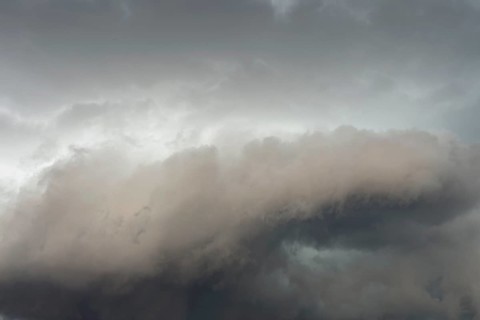 Below dark discoloured storm clouds Cloud roll above grey clouds Rain clouds heralding