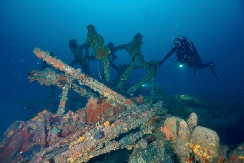 Diver examines the remains of an old shipwreck. Dive site wreck Ville de Grasse, Giens peninsula,