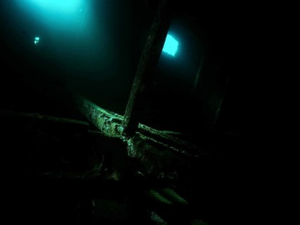 A mysterious, dark room in the shipwreck with blue light and shadows. Dive site wreck of the