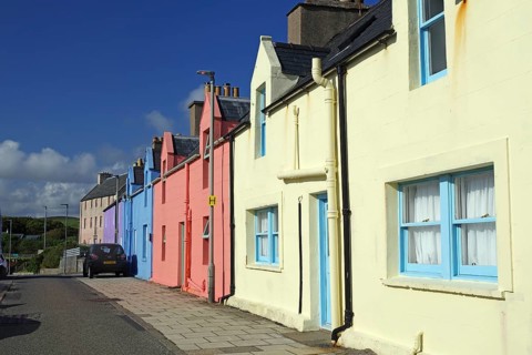 Brightly coloured house facade in sunny weather along a quiet street, Scalloway, Shetland Islands,