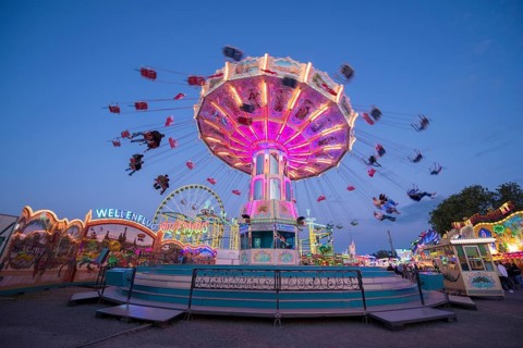 Colourful carousel in motion at a night fair, chain carousel, spring festival, Cannstatter