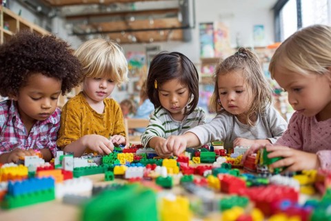 Children developing creativity while playing painting and drawing games at the table at daycare