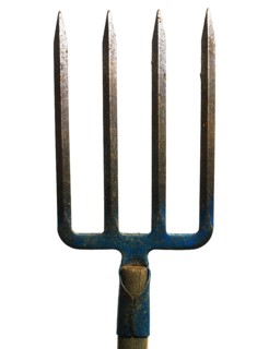 A metal fork with four sharp prongs stands upright against a plain white background. The wooden
