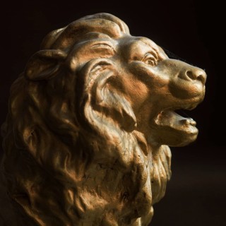 A lion head sculpture stands out with its detailed mane and expressive features. It captures the