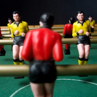 Engaged players immerse themselves in a lively tabletop football game, surrounded by vibrant player