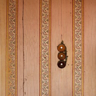 Intricate floral designs and charming stripes decorate the walls of an old building, while three