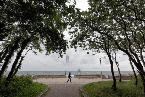 Single person walking along the beach promenade, cloudy sky, Baltic resort Kühlungsborn, Baltic