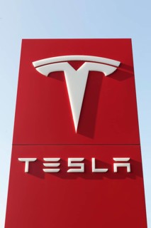Tesla, pillar with logo in front of Tesla repair shop, US car manufacturer for electric cars,