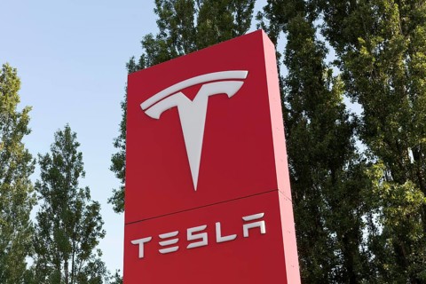 Tesla, pillar with logo in front of Tesla repair shop, US car manufacturer for electric cars,