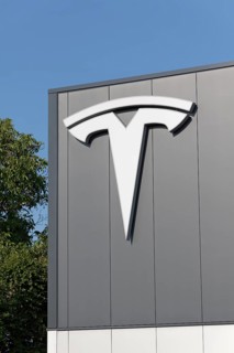 Tesla, logo on modern workshop building, figurative mark without lettering, US car manufacturer for