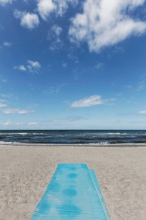 Deserted beach with blue sand mat for barrier-free beach access, blue sky, Kühlungsborn, Baltic