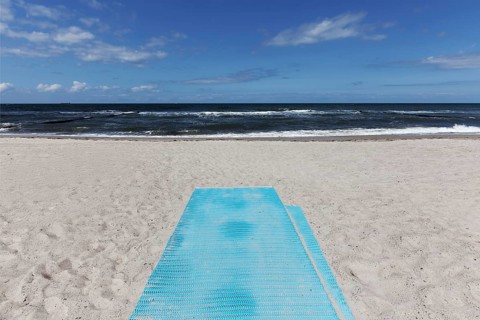 Deserted beach with blue sand mat for barrier-free beach access, blue sky, Kühlungsborn, Baltic