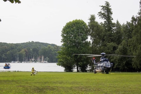 A firefighter transports a ladder to a helicopter in front of a joint meeting between Friedrich