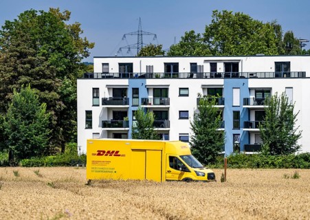 DHL parcel van, electric vehicle, on the way to a customer, rural, driving along a dirt track
