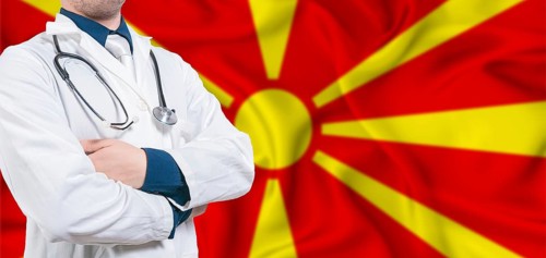 North Macedonia healthcare concept. Male doctor on North Macedonia flag. Doctor with crossed arms