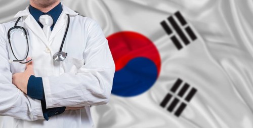 Male doctor with stethoscope on South Korea flag. Doctor holding stethoscope on South Korea flag
