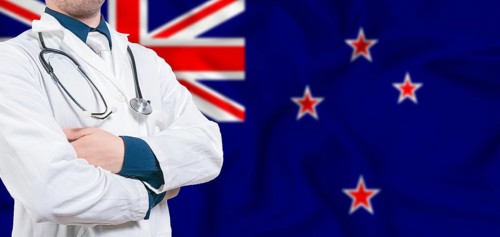 New Zealand healthcare concept. Male doctor on New Zealand flag. Doctor with crossed arms on New