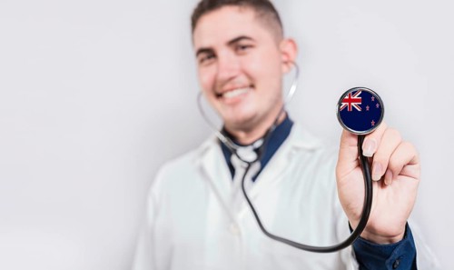 Doctor showing stethoscope with New Zealand flag. New Zealand national healthcare concept