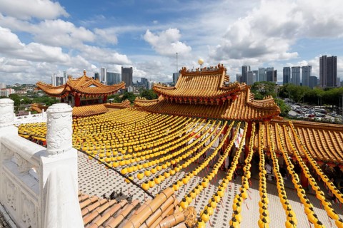 Thean Hou Temple to the Goddess Mazu with yellow chines lanterns and Kuala Lumpur skyline,