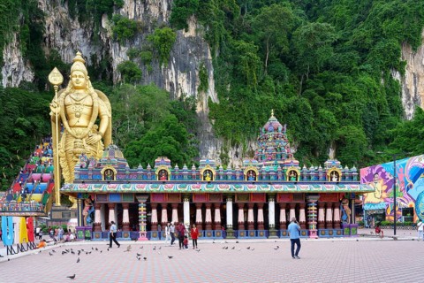 Murugan statue the God of War and colorful staircase leading to the caves with many pilgrims, Batu