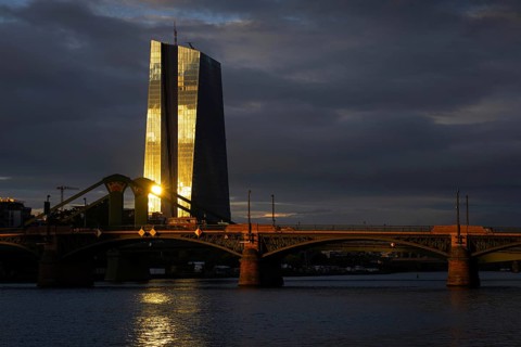 The light of the setting sun is reflected on the glass façade of the European Central Bank (ECB) in