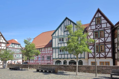 Colourful half-timbered houses, red, green, brown, empty benches, churchyard, Schmalkalden,