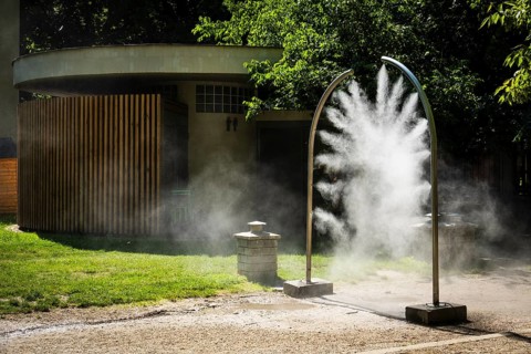 A mobile spray arch sprays fine water mist in a park in Bratislava, Slovakia