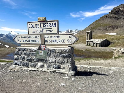 In the foreground signpost to the pass summit of the highest navigable alpine pass Col de l'Iseran