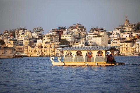 Excursion boats on Lake Pichola, behind the old town in the evening light, Udaipur, Rajasthan,