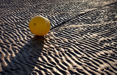 Buoy, yellow, on the sandy beach, Grandcamp-Maisy beach, low tide, evening light, Normandy,