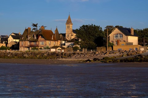 View at low tide from the beach to the church Église Notre-Dame de Grandcamp-Maisy, village,