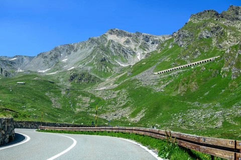 View of front curves of pass road mountain road alpine road above tree line, in the centre right in