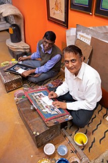 Miniature painters, 50 and 52 years old, painting pictures of the elephant and royal city palace in