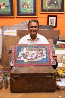 Miniature painter, 50 years old, shows a picture of the royal city palace in his studio, Udaipur,