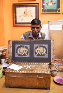 Miniature painter, 52 years old, shows a picture of the royal elephant in his studio, Udaipur,