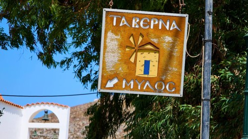 Restaurant Mylos, Rustic tavern sign with windmill motif next to trees, Agia Marina, Leros,