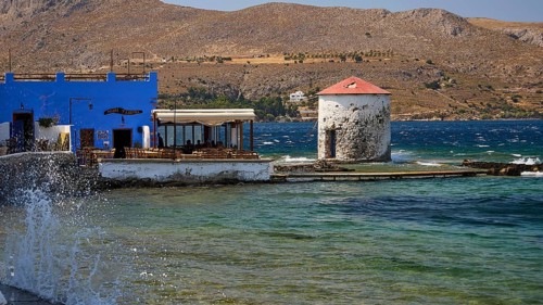 Restaurant Mylos, coastline with a windmill and a blue building by the sea, Agia Marina, Leros,
