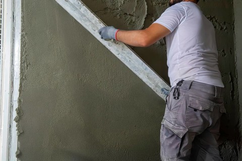 Plasterer smoothing interior walls