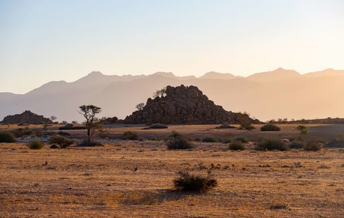 Desert landscape in the evening light at sunset, barren landscape with hills of stacked rocks,