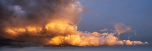Background image for sky replacement, evening sky with dramatic illuminated dark clouds at sunset,