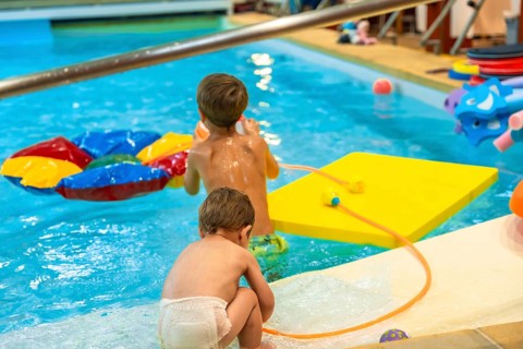 Two brothers enjoying playful moments with inflatable toys in a swimming pool, embracing the joy of