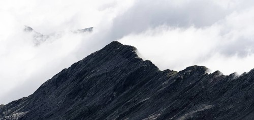 Mountain ridge with summit Zunderspitz and summit cross, cloudy, Stubai Alps, near Ridnaun, South