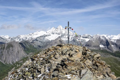 Summit cross of the summit Böses Weibl, behind summit of the Großglockner with snow, Schober group,
