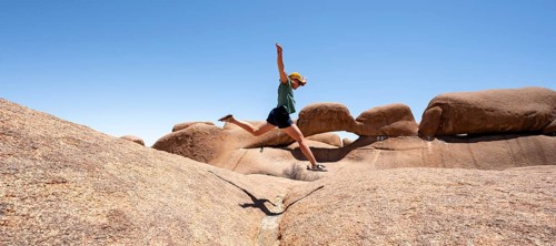 Tourist jumping over rocks, rock formation, Pontok Mountains, Spitzkoppe, Great Spitzkuppe Nature