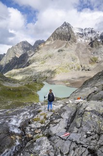 Mountaineer on a rocky hiking trail, view of the turquoise-blue mountain lake Großer Gradensee,