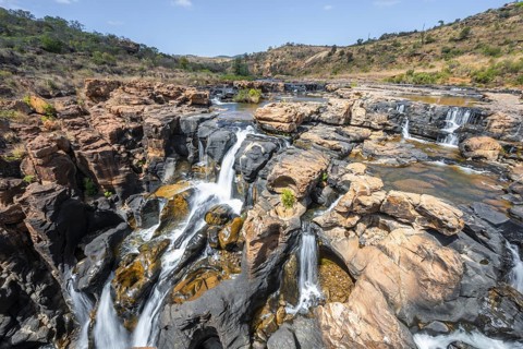 Waterfall on orange-coloured rock cliffs, long exposure, Blyde River, Bourke's Luck Potholes,