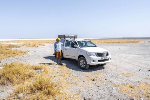 Tourist with off-road car exploring dry landscape, Kubu Island (Lekubu), Sowa Pan, Makgadikgadi